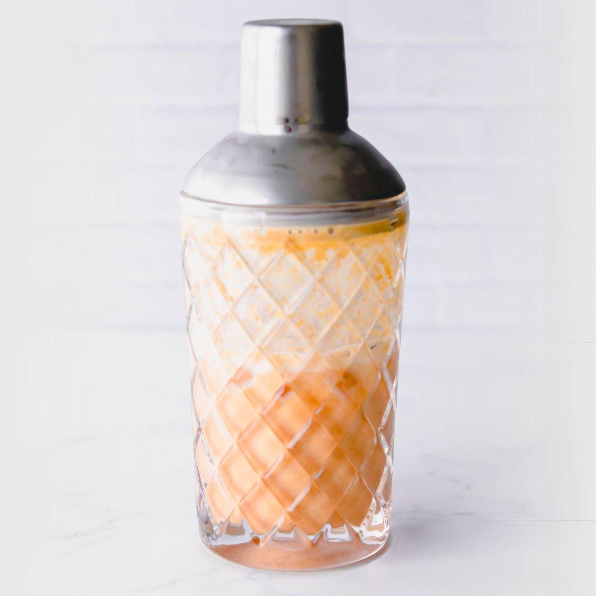 Crystal cocktail shaker with a mixed pumpkin pie martini inside
