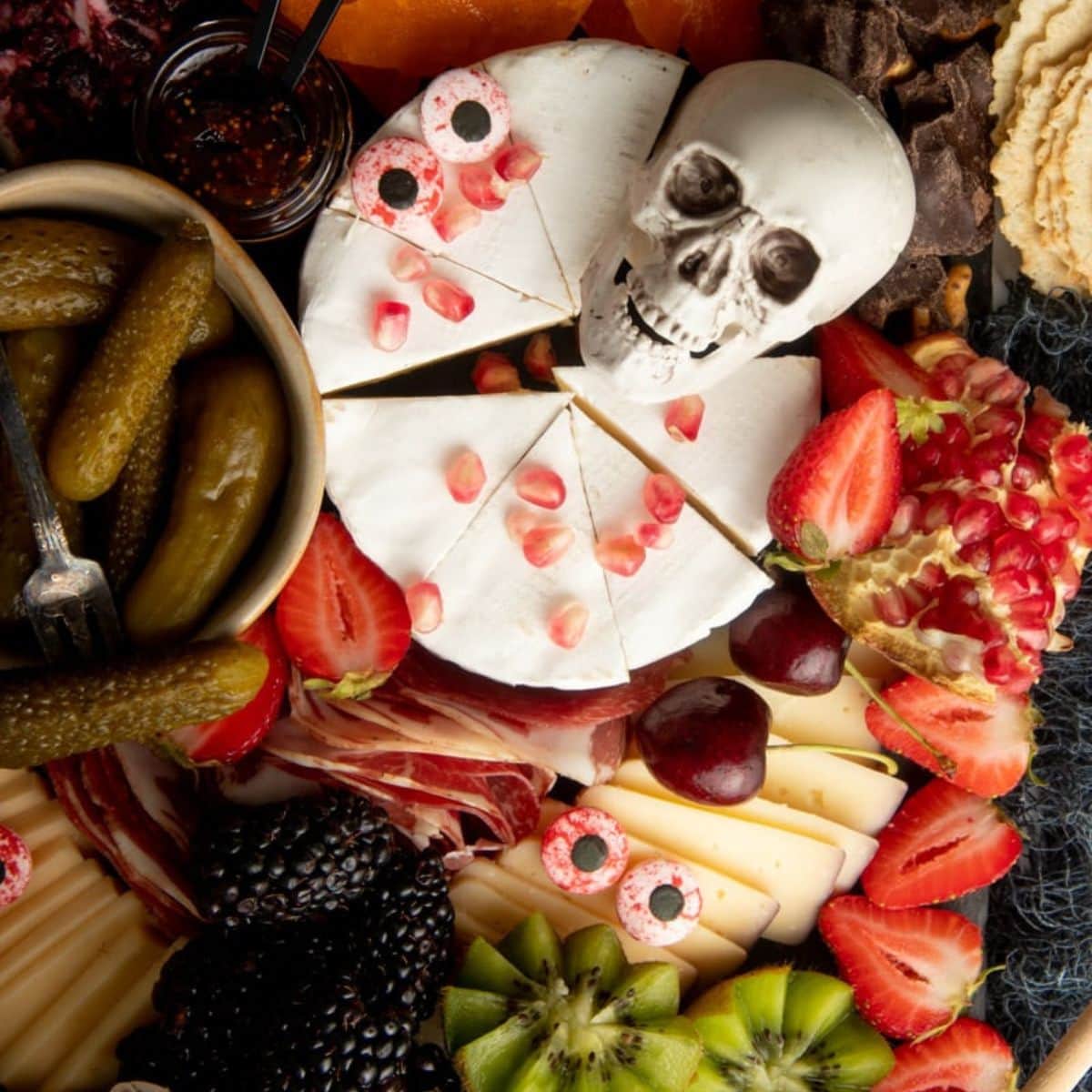 Halloween cheese board with candy eyes and plastic skulls