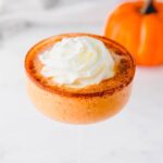 Whipped cream and cinnamon garnish on top of a pumpkin martini