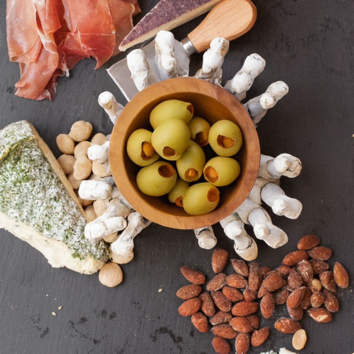 Olives and almonds added to a black cheese board