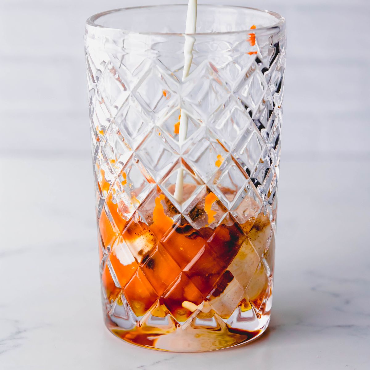 Combining ingredients for pumpkin pie martini in a crystal cocktail shaker