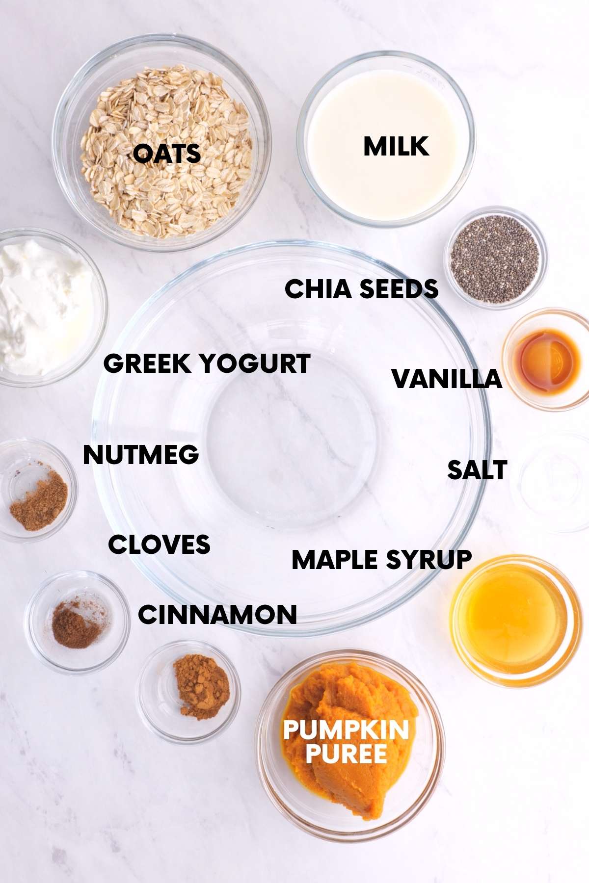 Ingredients for pumpkin overnight oats sit on a white marble countertop