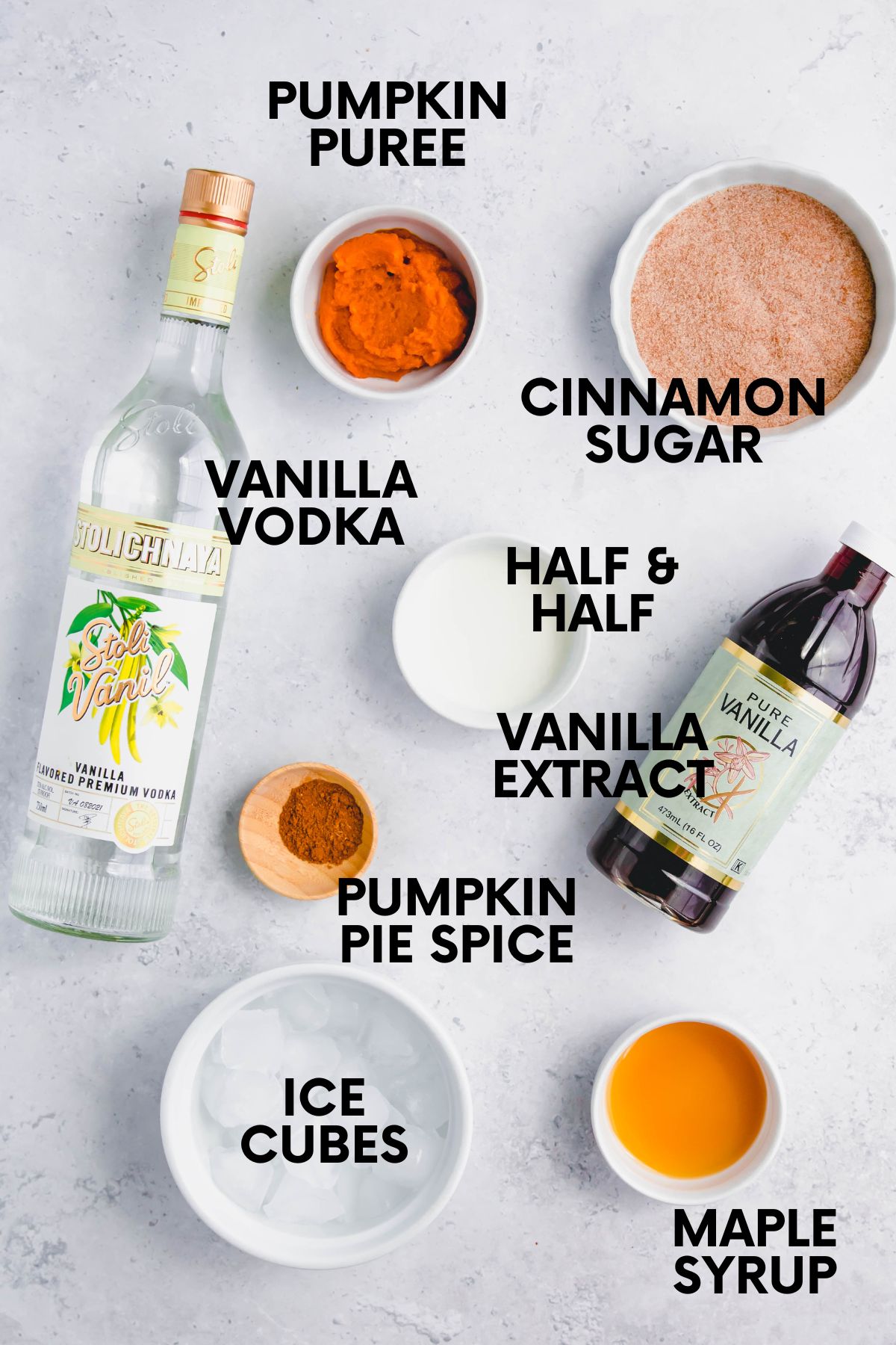 Ingredients for making a pumpkin pie martini on a white marble countertop