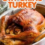 A roasted turkey in a roasting pan with the text overlay "Dry Brine Turkey"