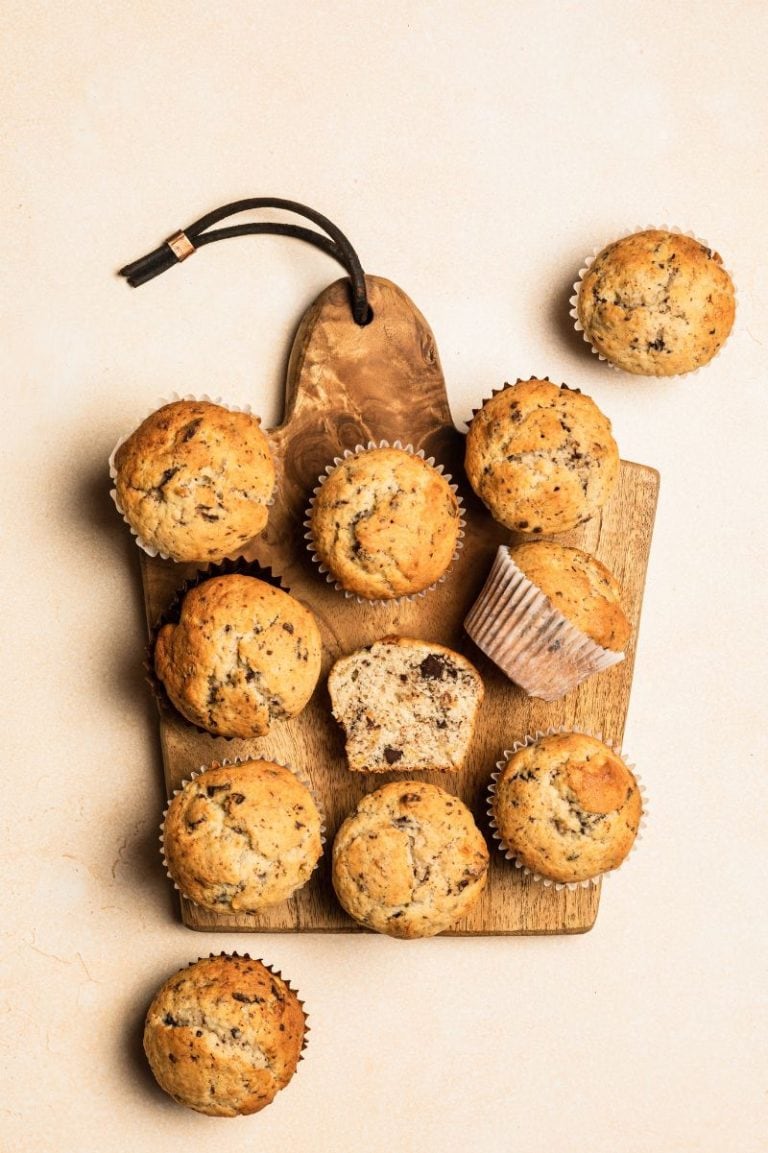 Overhead of gluten-free banana muffins on a wooden cutting serving board.