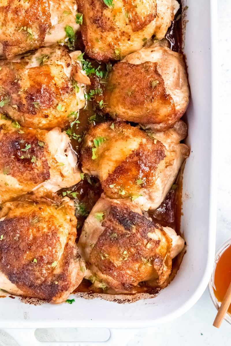 Top view of baked bone-in skin-on chicken thighs in a sticky sauce.