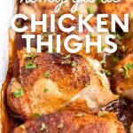 Tight view of skin on chicken thighs in a baking dish with a flavorful sauce. A text overlay reads, "Honey Garlic Chicken Thighs."