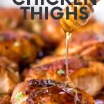 A honey dipper drizzles honey onto a baked sticky chicken thigh. A text overlay reads, "Honey Garlic Chicken Thighs."