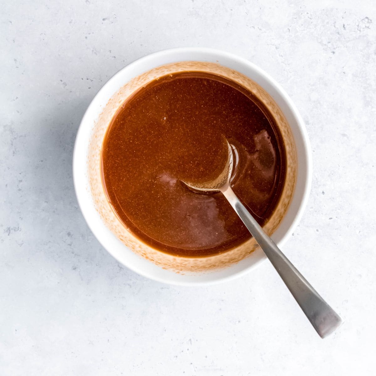 Honey garlic sauce stirred together in a white bowl