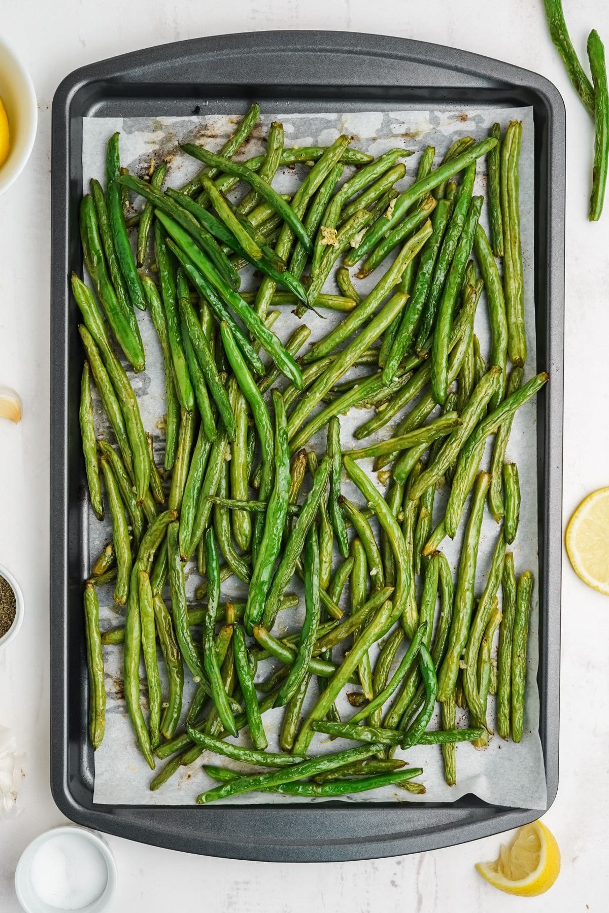 Roasted green beans with charred edges on a metal sheet pan