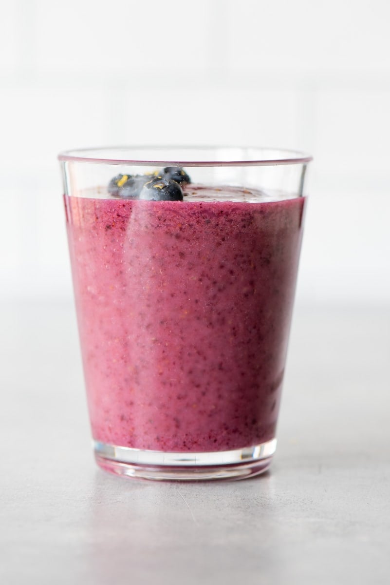 Lemon and blueberries blended together with canned pears and unsweetened nut milk and served in a tall glass.