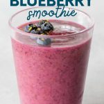 Top view of a blueberry smoothie topped with fresh berries and lemon zest. A text overlay reads, "Banana-Free Lemon Blueberry Smoothie."
