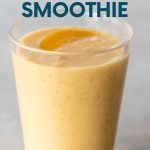 Top view of a peach smoothie in a glass with a peach slice on top. A text overlay reads, "Banana-Free Peach Smoothie."