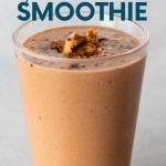A peanut butter smoothie topped with a scoop of peanut butter and a sprinkling of cocoa powder in a glass on a light background. A text overlay reads, "Banana-Free Peanut Butter Smoothie."