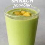 Top view of a pineapple spinach smoothie in a glass with pineapple pieces on top. A text overlay reads, "Banana-Free Pineapple Spinach Smoothie."