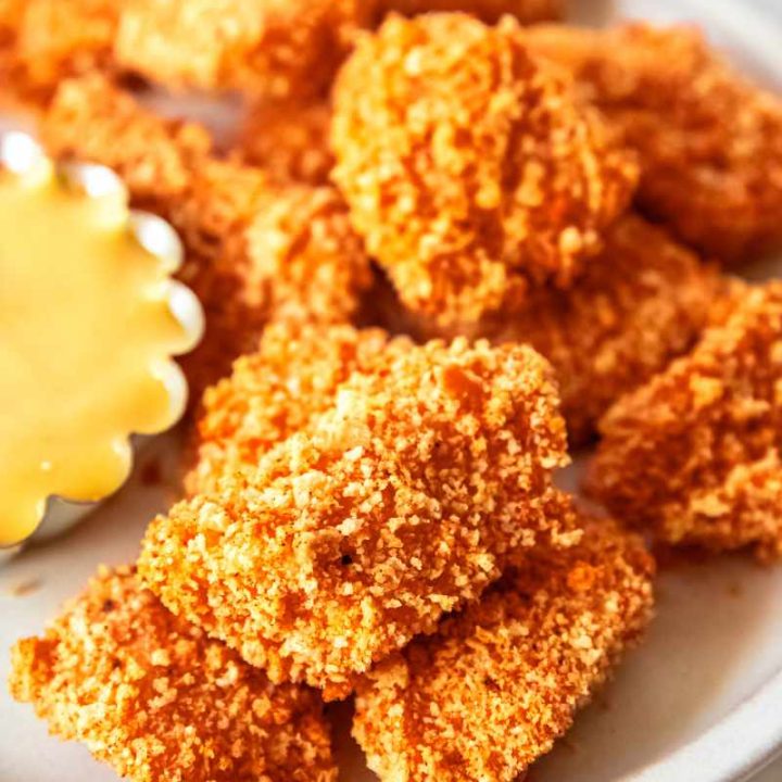 Homemade chicken nuggets on a white platter.