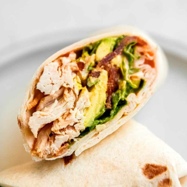 Cross section of a cut chicken bacon ranch wrap showing all the ingredients wrapped inside.