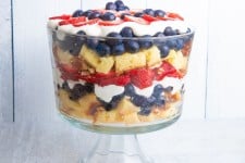 Closer view of a festive berry trifle in a trifle dish on a light background.