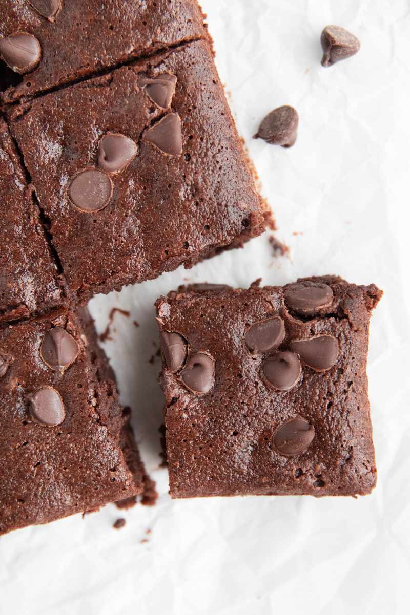 Close view of a corner gluten-free brownie square slightly pulled away from the rest of the brownies.