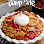 Serving fruity strawberry dessert scooped into a bowl with whipped topping. A text overlay reads, "Strawberry Dump Cake."