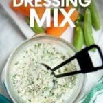 Top view of a jar of ranch dressing mix with a tablespoon scoop in it. A text overlay reads, "Ranch Dressing Mix."