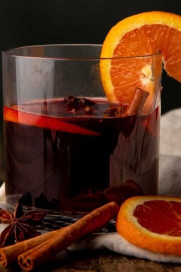 Apple cider sangria in a clear class with an orange slice on the rim