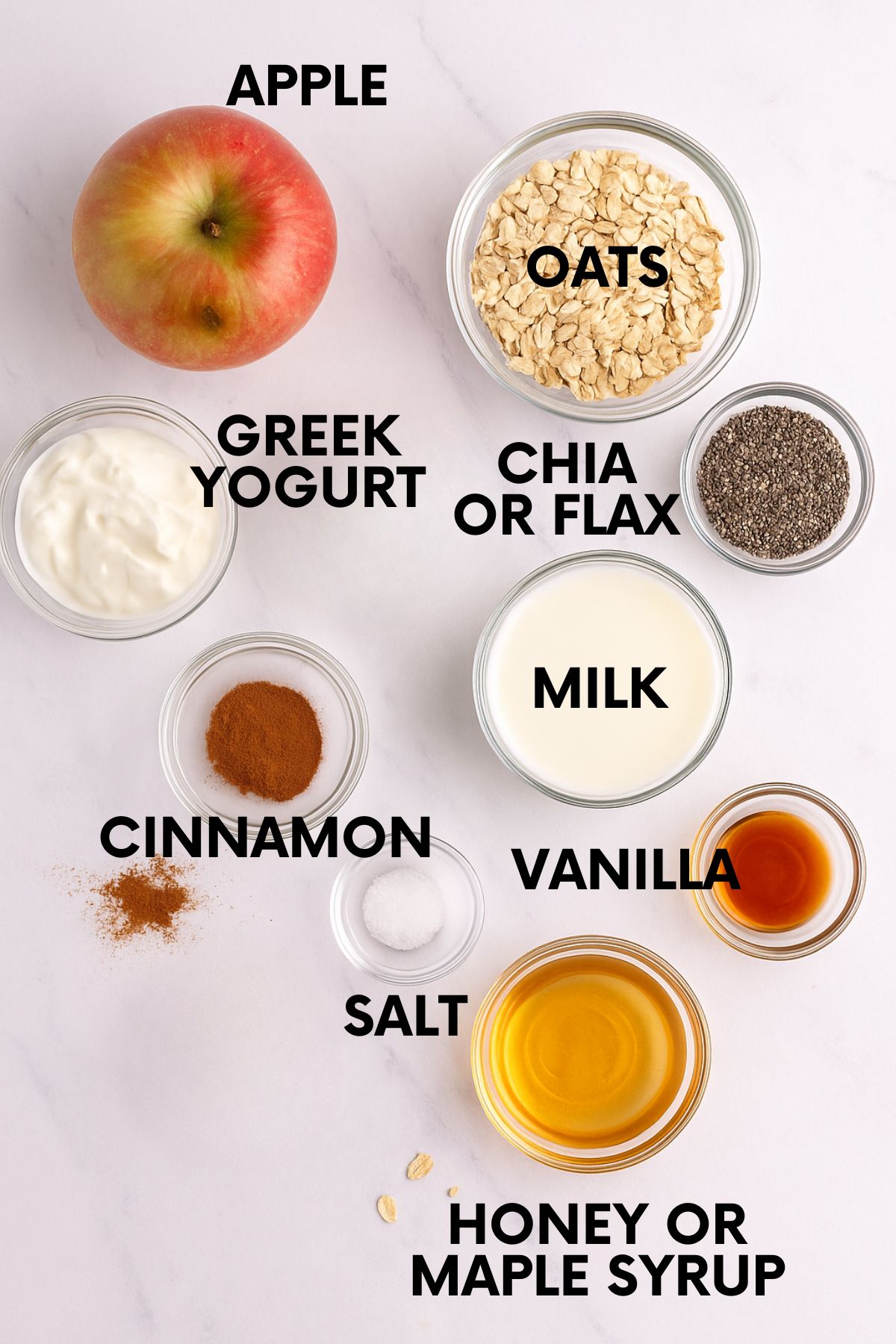 Ingredients for apple overnight oats on a white marble countertop