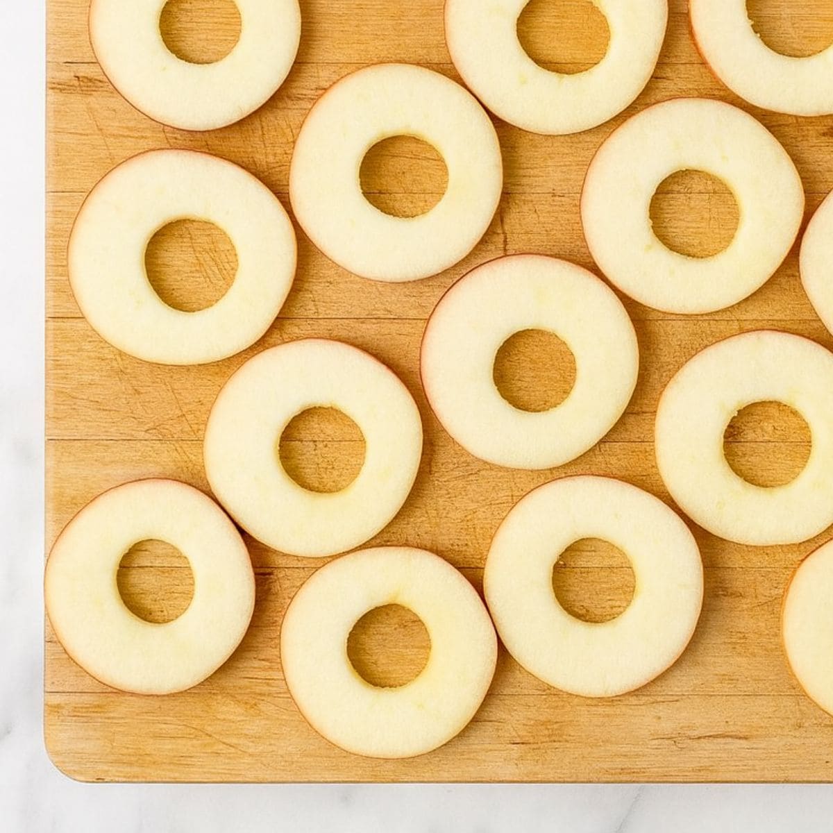 Cored apple slices on a cutting board