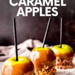 Three caramel apples each with a different topping, lined up in a row on parchment paper. A text overlay reads, "Homemade Caramel Apples."