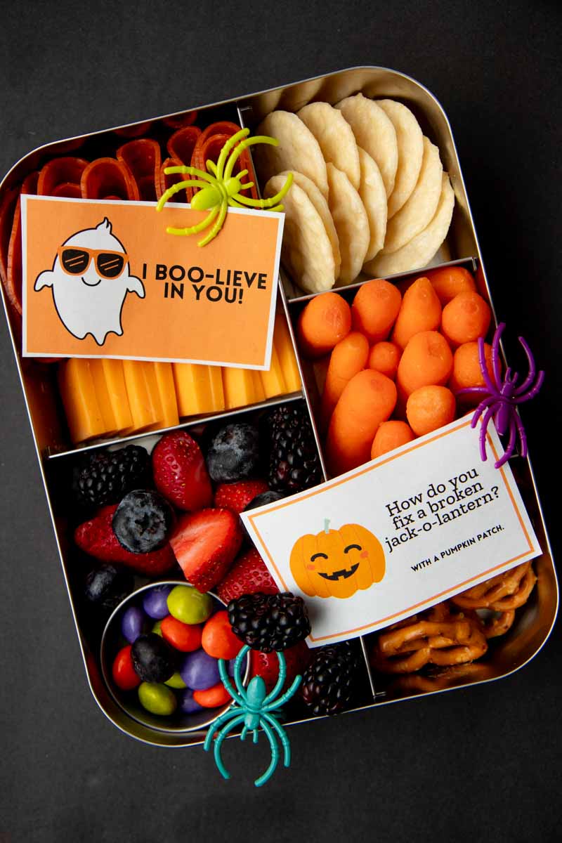 Two cute Halloween notes atop a bento-style school lunch.