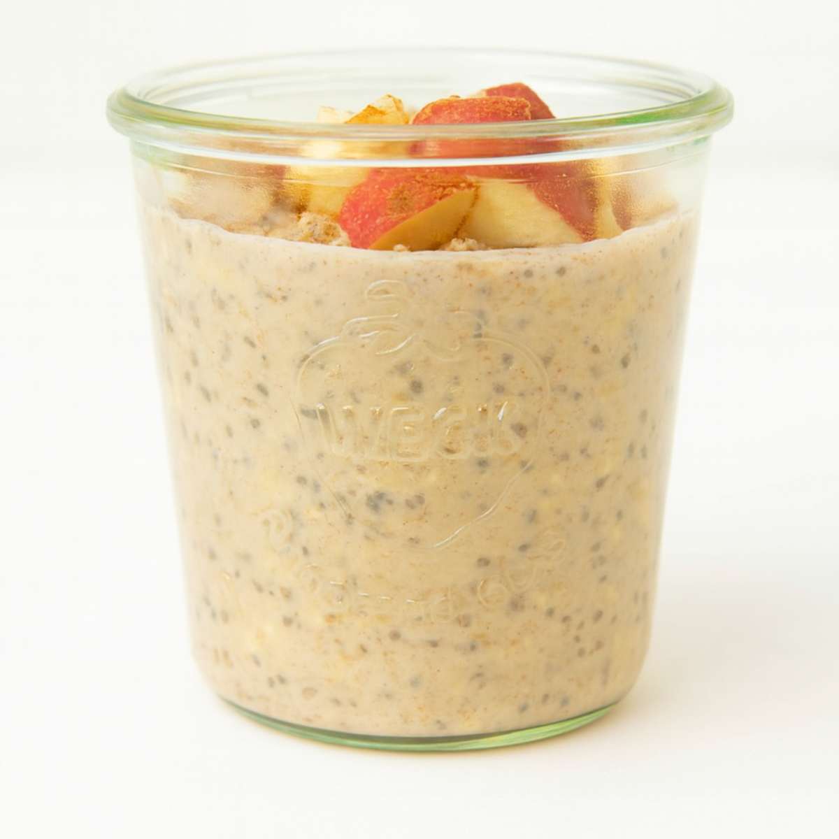 Jar of apple cinnamon overnight oats on a white background