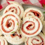Top view of two pepperoni pinwheels atop other pinwheel bites, the pepperoni spirals deliciously displayed.