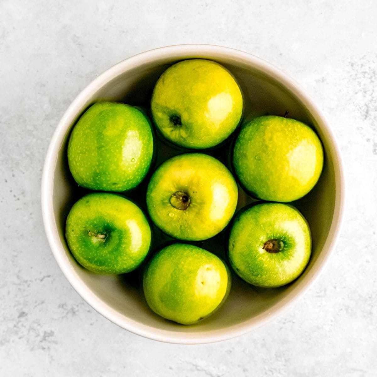 A bowl of apples soaking in a vinegar solution