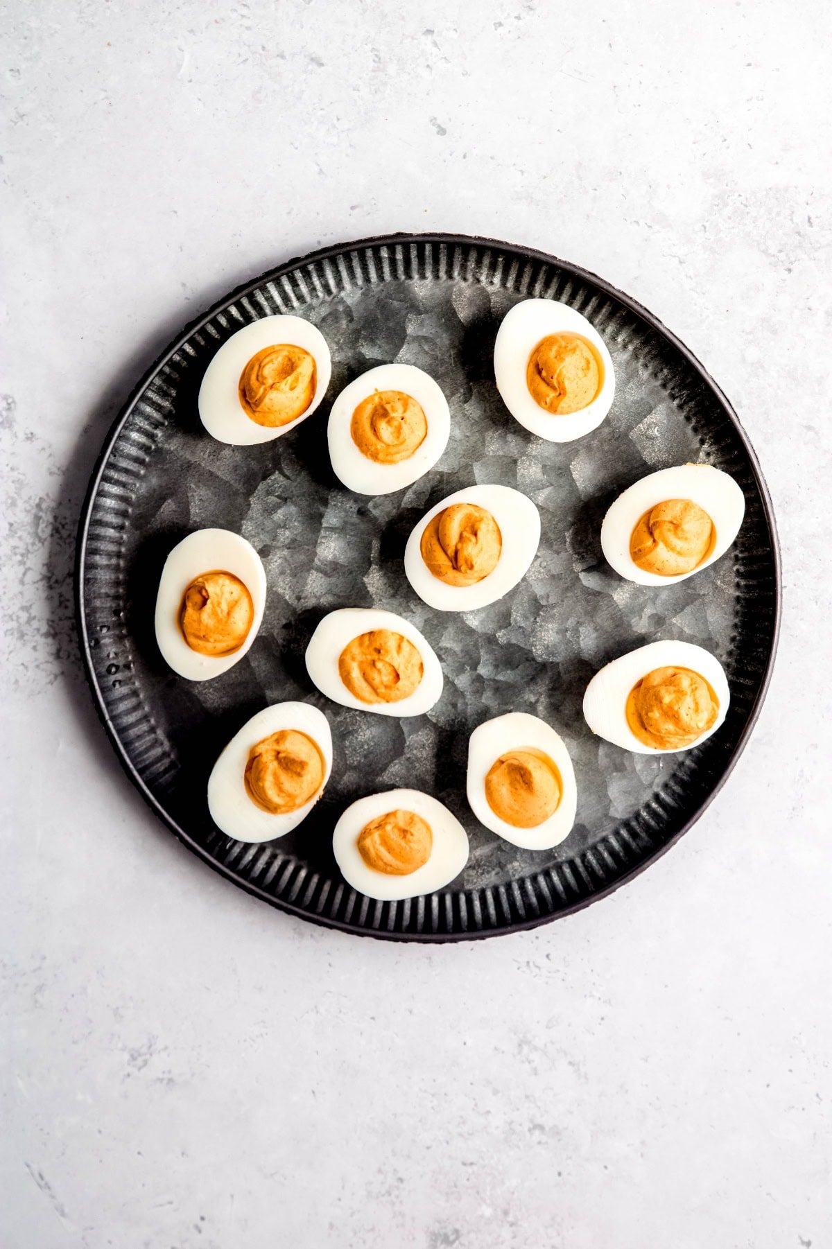 Hard-boiled egg halves piped with orange filling.