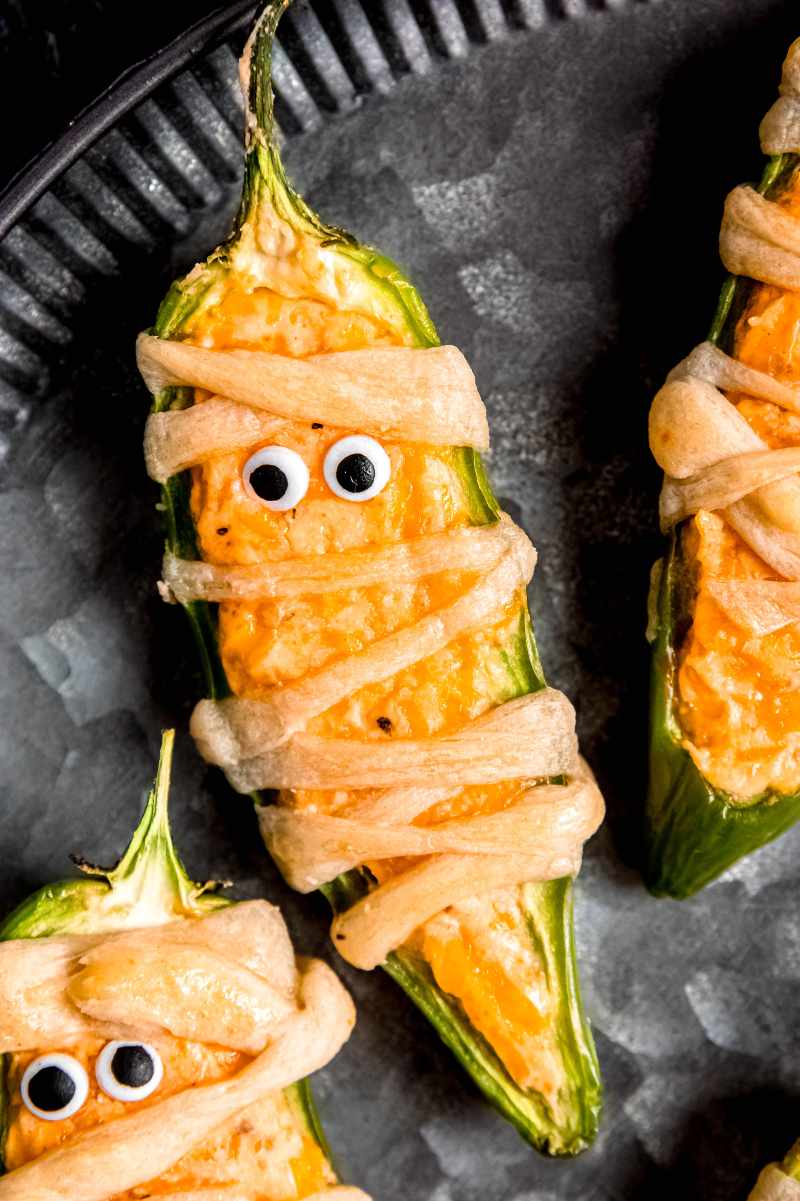 Close view of a spooky mummy appetizer on a dark tray.