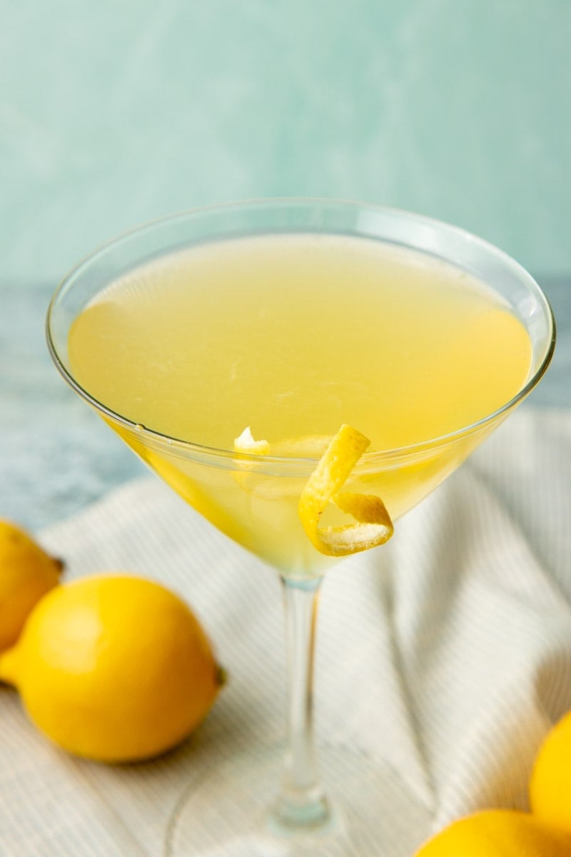A chilled limoncello cocktail in a tall footed glass with a lemon twist on the rim.