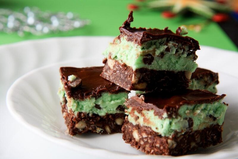 Close view of homemade mint chocolate bars stacked on a plate, three distinct layers in each bar.