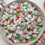 Overhead of a bowl of reindeer chow surrounded by festive red and white decorations.