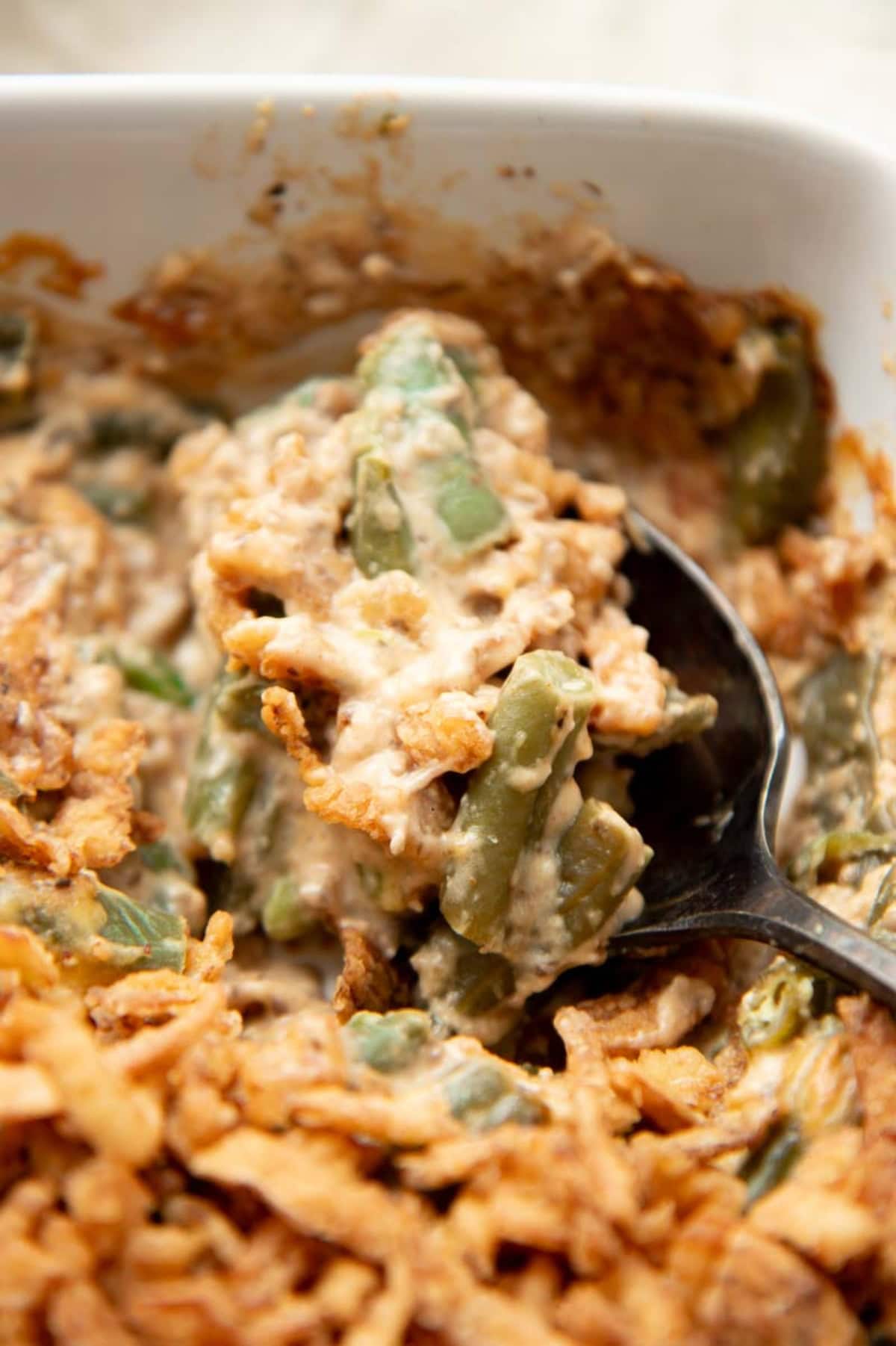 A spoon scoops a serving of fresh green bean casserole.