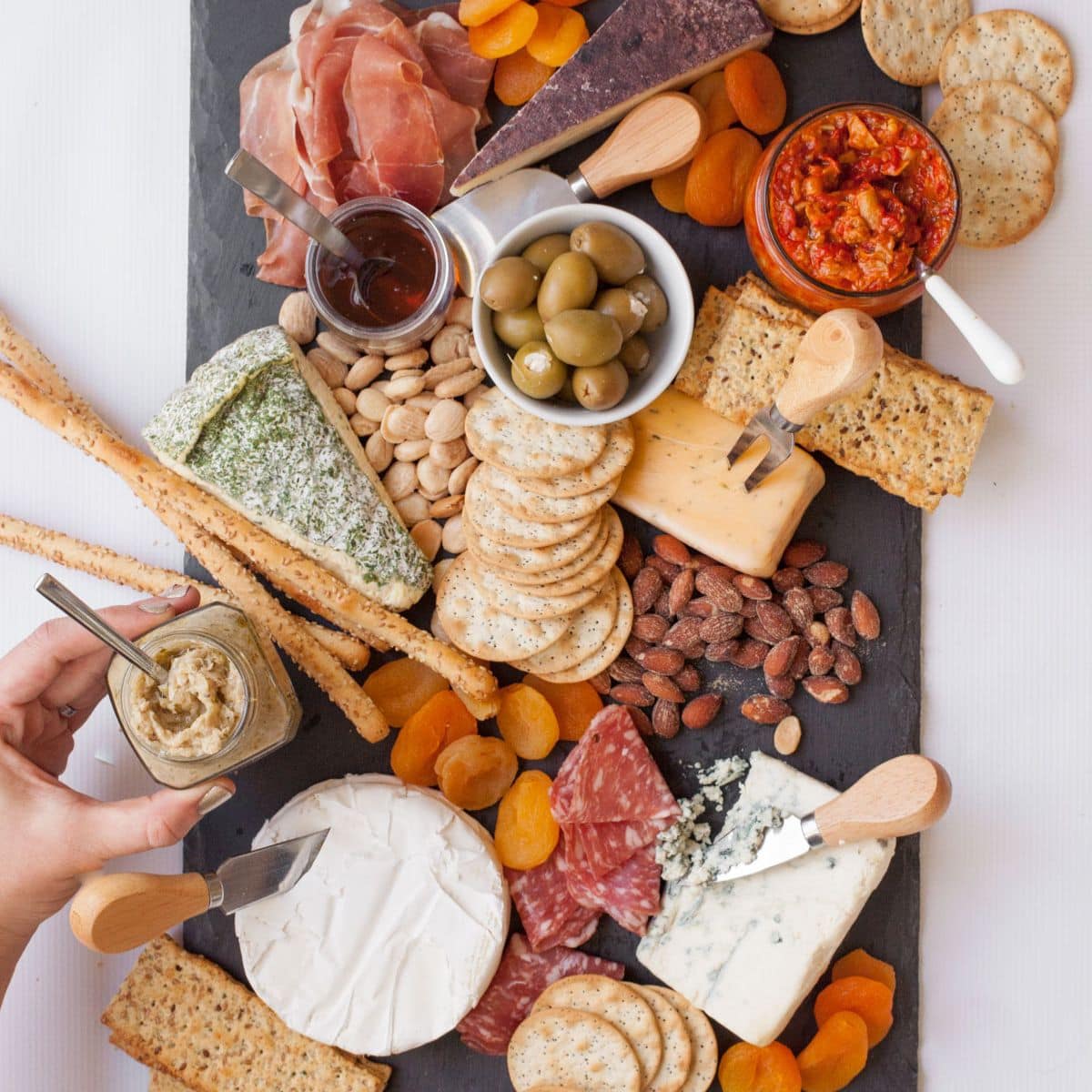 Adding jar of chutney to a cheese platter