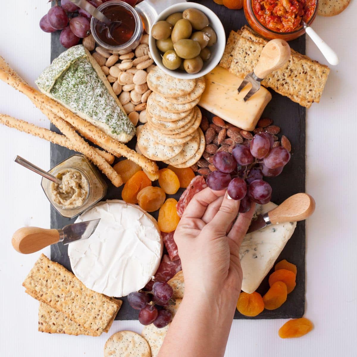 Adding grapes to a cheese platter
