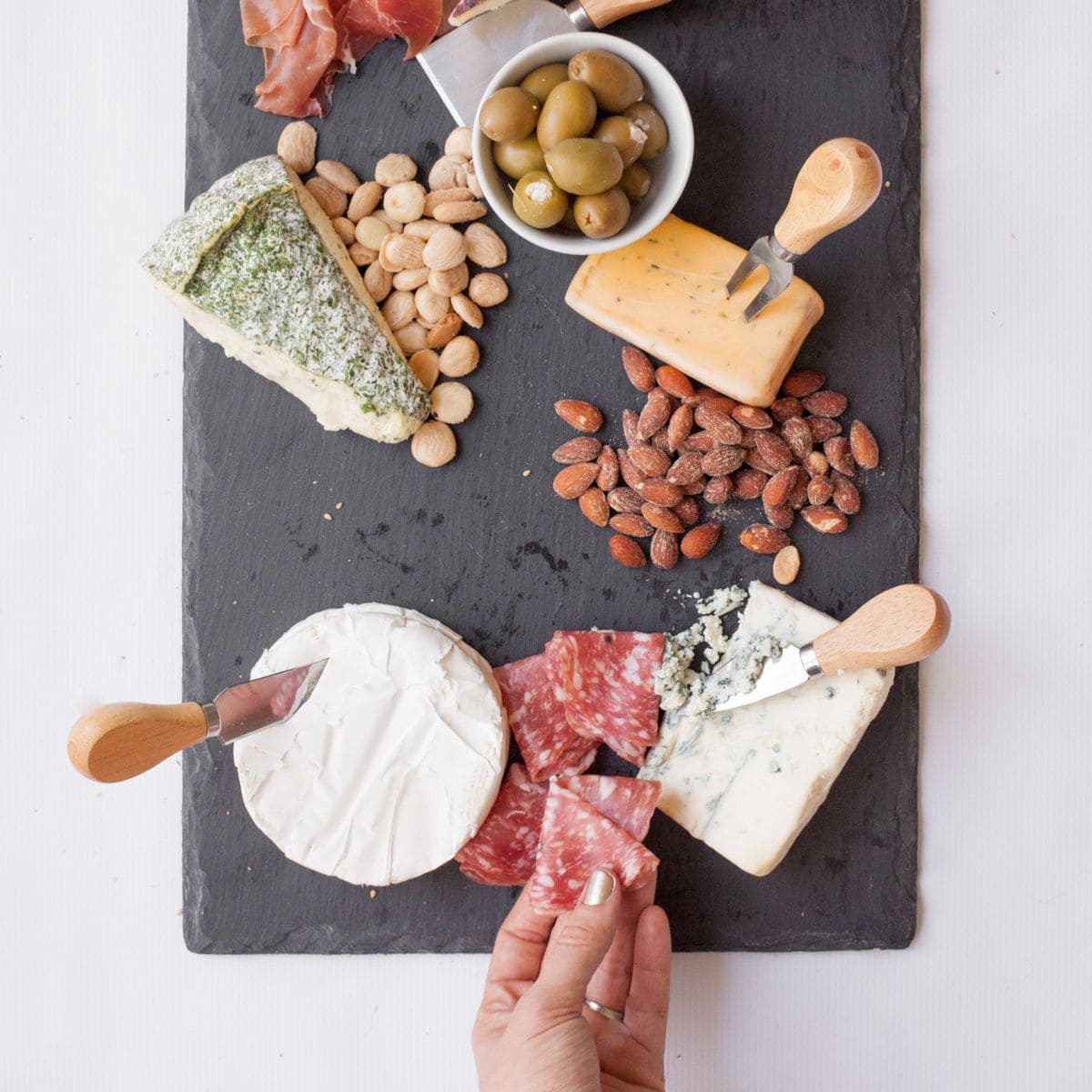 Adding meat and nuts to a cheese platter