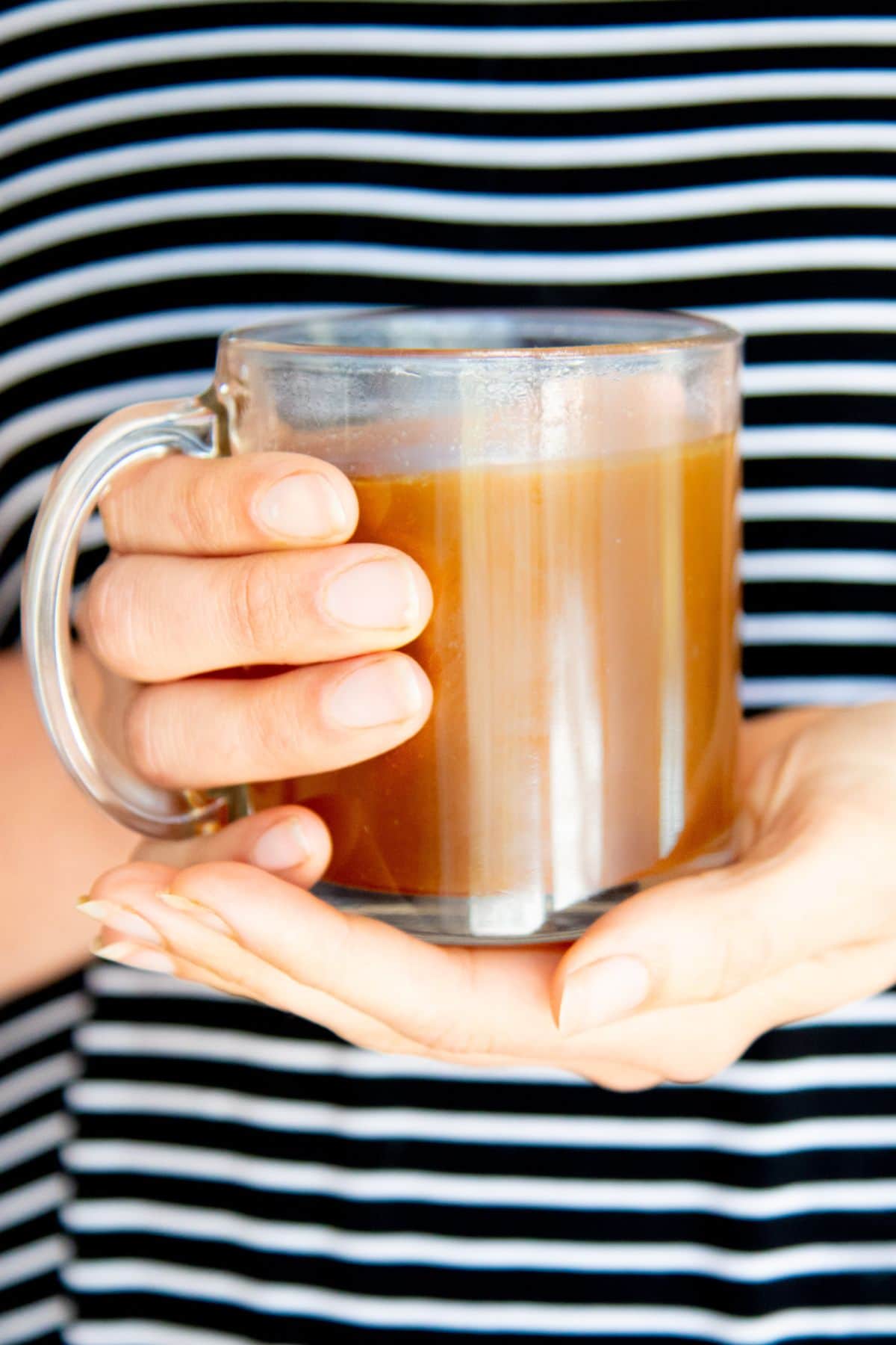 Hands hold a mug of chicken bone broth