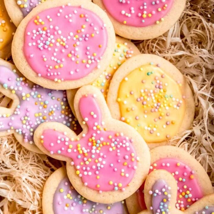 Easter sugar cookies frosted with pink, purple, and yellow icing and topped with pastel sprinkles.