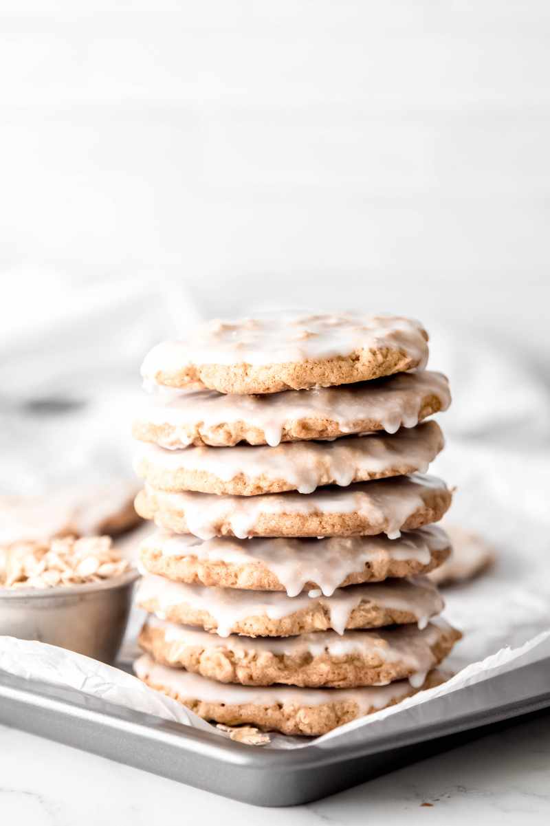 Chewy iced cookies stacked high on a tray.