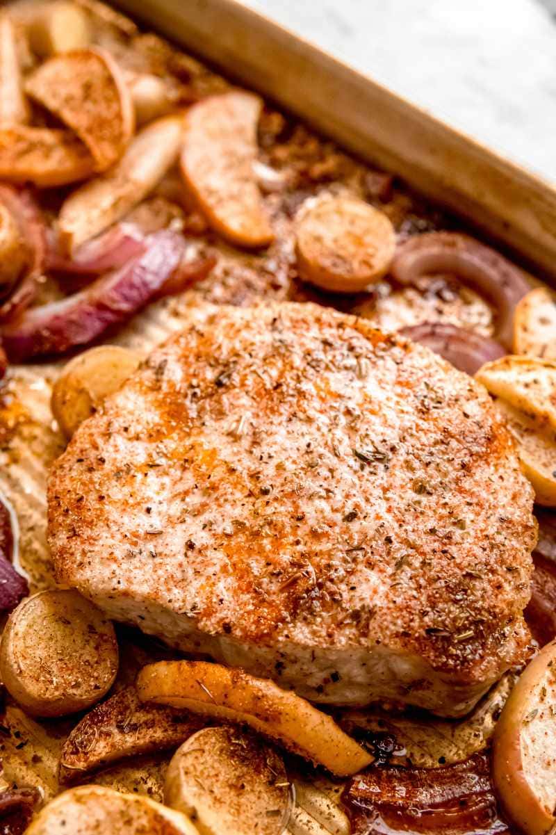 Close view of sheet pan pork chops with apples and potatoes.