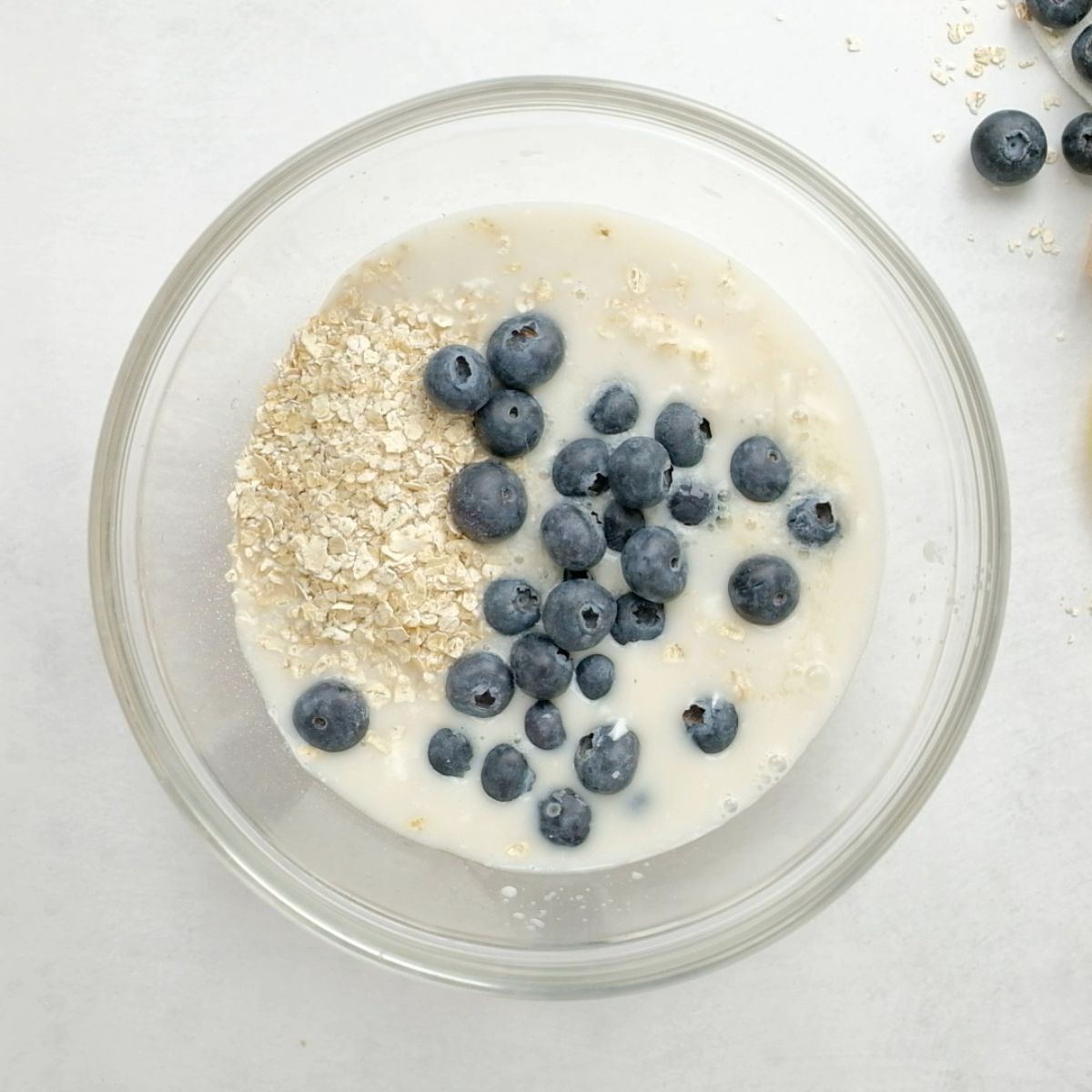 Blueberry overnight oats ingredients in a bowl on a counter
