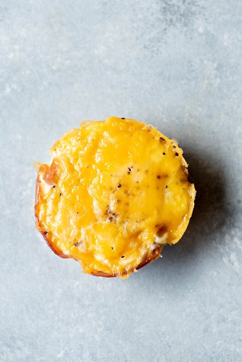 Top view of a ham and cheddar egg bite on a light counter.