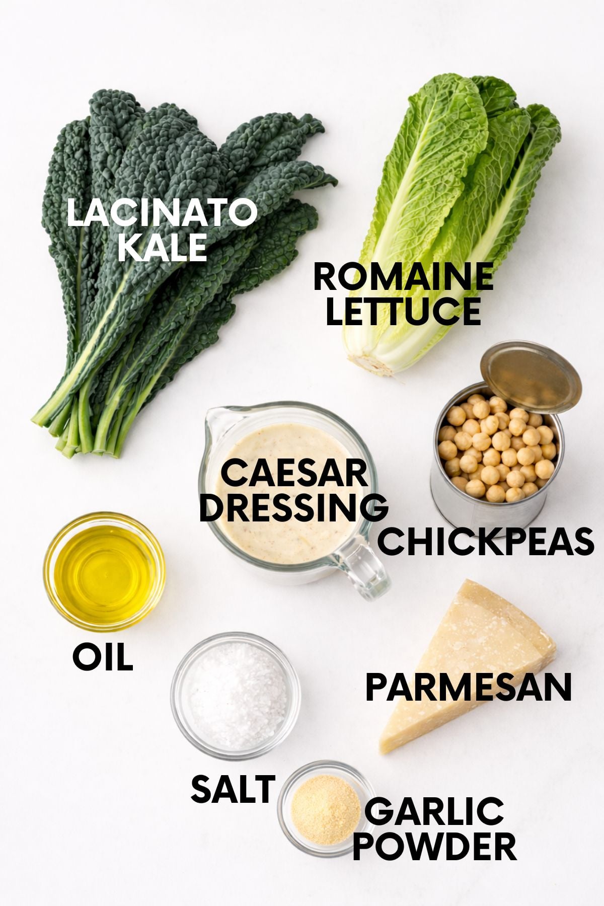Labeled ingredients for kale caesar salad, including lacinato kale, romaine lettuce, caesar dressing, chickpeas, olive oil, parmesan, salt, and garlic powder.