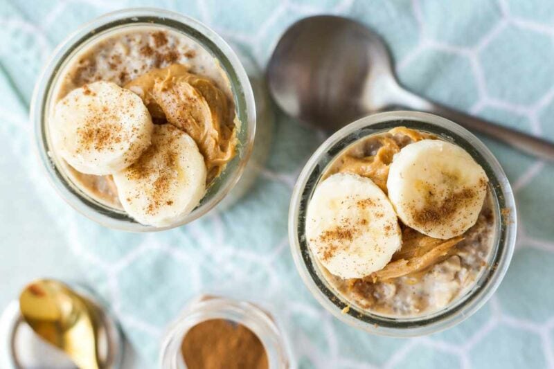 Tight view of peanut butter banana breakfast oats in two glass jars.